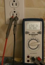 Digital voltmeter used to test voltage at wall outlet